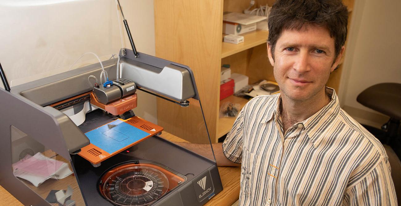 Dr. 计算机学院助理教授Mark Yampolskiy与3D打印设备合影