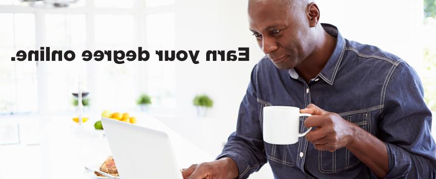 Man drinking coffee working on laptop with caption Earn Your Degree Online