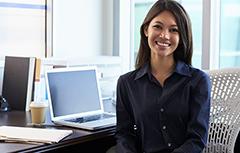 Woman sitting at desk with computer smiling